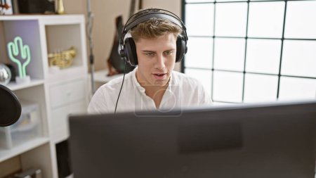 Photo for Young caucasian man musician listening to music with serious face at music studio - Royalty Free Image