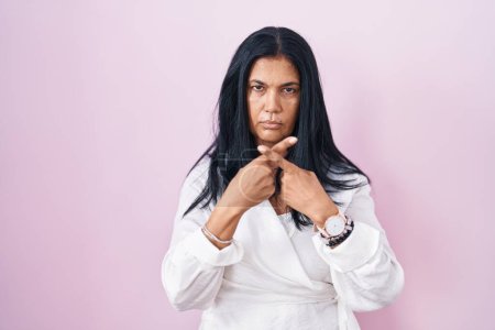Téléchargez les photos : Femme hispanique mature debout sur fond rose expression de rejet croisant les doigts faisant signe négatif - en image libre de droit
