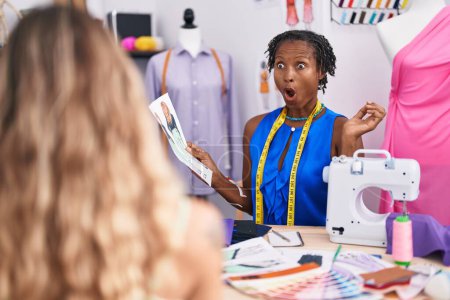 Photo for African woman with dreadlocks dressmaker designer at atelier with customer scared and amazed with open mouth for surprise, disbelief face - Royalty Free Image