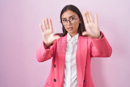 Foto de Mujer hispana joven usando ropa de negocios y gafas haciendo marco usando manos palmas y dedos, perspectiva de la cámara - Imagen libre de derechos