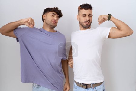 Téléchargez les photos : Homosexuel gay couple debout sur fond blanc étirement dos, fatigué et détendu, somnolent et bâillant pour tôt le matin - en image libre de droit