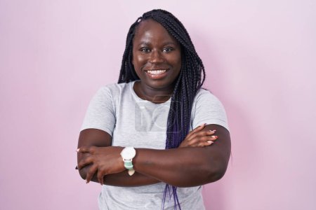Téléchargez les photos : Jeune femme africaine debout sur fond rose heureux visage souriant avec les bras croisés regardant la caméra. personne positive. - en image libre de droit