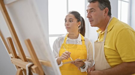 Photo for In an art studio, a man and woman artists passionately drawing together, intensively focused and calm amidst easels and paintbrushes - Royalty Free Image