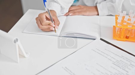 Photo for Hands of woman scientist taking notes at laboratory - Royalty Free Image