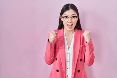 Téléchargez les photos : Entreprise chinoise jeune femme portant des lunettes célébrant surpris et étonné pour le succès avec les bras levés et les yeux ouverts. concept gagnant. - en image libre de droit