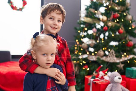 Photo for Adorable boy and girl hugging each other celebrating christmas at home - Royalty Free Image