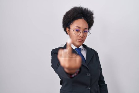 Foto de Beautiful african woman with curly hair wearing business jacket and glasses showing middle finger, impolite and rude fuck off expression - Imagen libre de derechos