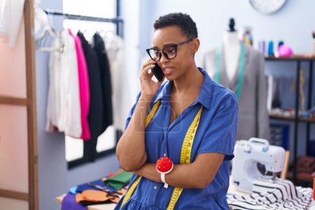 Téléchargez les photos : Femme afro-américaine tailleur parler sur smartphone au magasin de tailleur - en image libre de droit