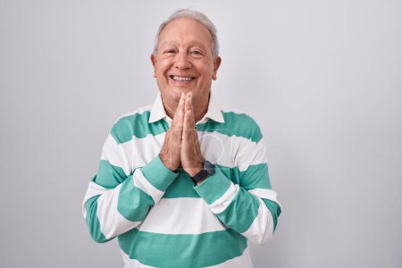 Photo for Senior man with grey hair standing over white background praying with hands together asking for forgiveness smiling confident. - Royalty Free Image