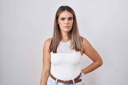 Photo for Hispanic young woman standing over white background skeptic and nervous, frowning upset because of problem. negative person. - Royalty Free Image
