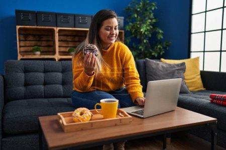 Téléchargez les photos : Young beautiful plus size woman having breakfast using laptop at home - en image libre de droit