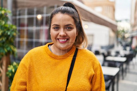 Photo for Young beautiful plus size woman smiling confident standing at coffee shop terrace - Royalty Free Image