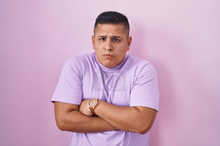 Téléchargez les photos : Young hispanic man standing over pink background shaking and freezing for winter cold with sad and shock expression on face - en image libre de droit