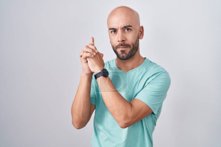 Photo for Middle age bald man standing over white background holding symbolic gun with hand gesture, playing killing shooting weapons, angry face - Royalty Free Image