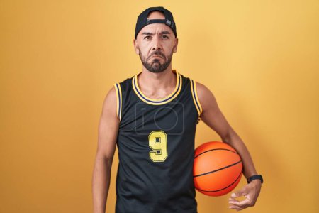 Photo for Middle age bald man holding basketball ball over yellow background depressed and worry for distress, crying angry and afraid. sad expression. - Royalty Free Image