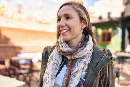 Téléchargez les photos : Young blonde woman smiling confident looking to the side at street - en image libre de droit
