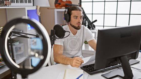 Téléchargez les photos : Jeune reporter hispanique enregistrant une vidéo parlant à la radio au studio de radio - en image libre de droit
