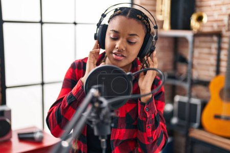 Téléchargez les photos : Femme musicienne afro-américaine chantant au studio de musique - en image libre de droit