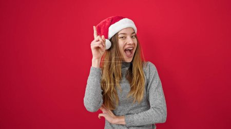 Téléchargez les photos : Jeune femme caucasienne portant un chapeau de Noël avec expression d'idée sur fond rouge isolé - en image libre de droit