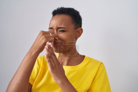 Téléchargez les photos : Femme afro-américaine dong mauvais geste olfactif sur fond blanc isolé - en image libre de droit