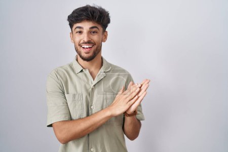 Téléchargez les photos : Homme arabe avec barbe debout sur fond blanc applaudissements et applaudissements heureux et joyeux, souriant mains fières ensemble - en image libre de droit