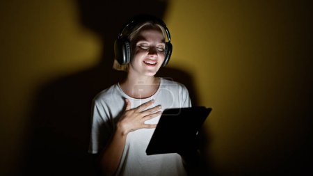 Photo for Young blonde woman smiling confident listening to music dancing over isolated yellow background - Royalty Free Image