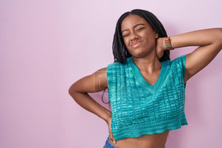 Photo for Young african american with braids standing over pink background suffering of neck ache injury, touching neck with hand, muscular pain - Royalty Free Image