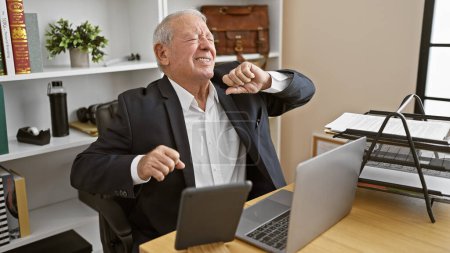 Photo for Exhausted senior man working hard on task, stretching back in his business office while sitting at desk - Royalty Free Image