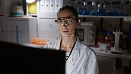 Photo for Young beautiful hispanic woman scientist wearing glasses using computer smiling at laboratory - Royalty Free Image