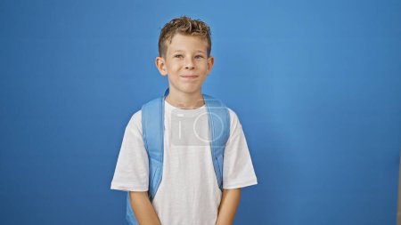 Foto de Rubio chico estudiante sonriendo confiado sobre aislado azul fondo - Imagen libre de derechos