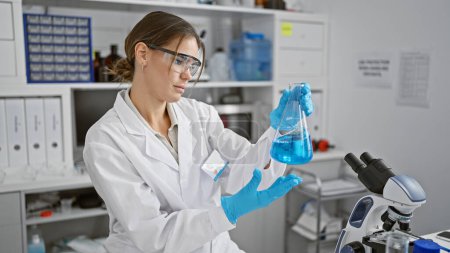 Photo for Attractive young hispanic female scientist measuring liquid in a test tube, engrossed in her groundbreaking medical research at the bustling lab, showcasing the beauty of scientific endeavor. - Royalty Free Image