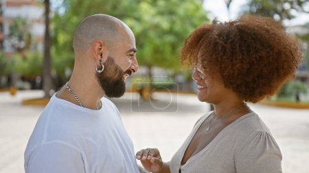 Téléchargez les photos : Beau couple debout ensemble se regardant souriant au parc - en image libre de droit