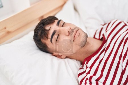 Photo for Young hispanic man lying on bed sleeping at bedroom - Royalty Free Image