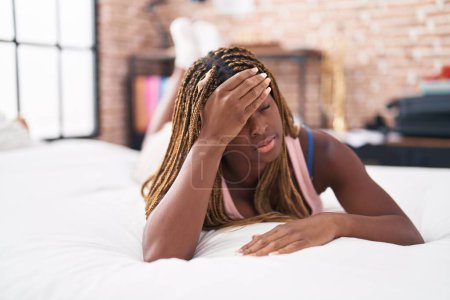 Foto de Mujer afroamericana estresada acostada en la cama en el dormitorio - Imagen libre de derechos