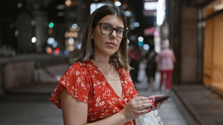 Téléchargez les photos : Belle femme hispanique avec des lunettes à Tokyo, connexion numérique via smartphone dans les rues de la ville - en image libre de droit