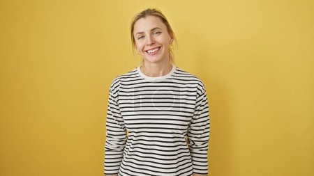 Photo for A smiling young caucasian woman in a striped shirt against a vibrant yellow background exudes a casual, approachable vibe. - Royalty Free Image
