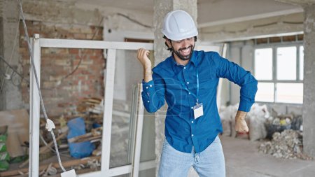 Photo for Young hispanic man architect smiling confident dancing at construction site - Royalty Free Image