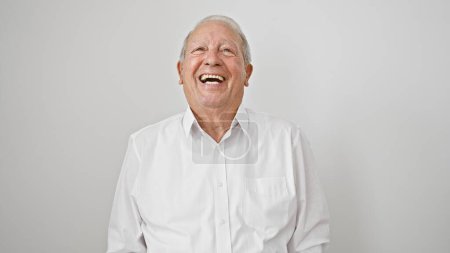 Foto de Instantánea casual de un hombre mayor alegre y sonriente, lleno de confianza y alegría, de pie sobre un fondo blanco aislado, irradiando felicidad en su estilo de vida maduro. - Imagen libre de derechos