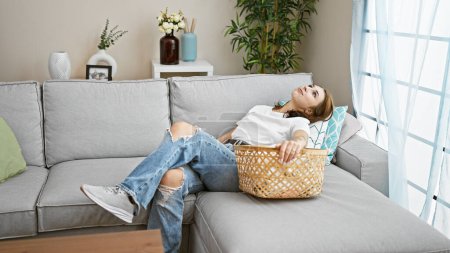 Photo for Young woman relaxing on sofa at home - Royalty Free Image