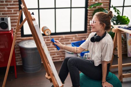 Téléchargez les photos : Jeune femme blonde artiste dessin avec peinture à rouleau au studio d'art - en image libre de droit