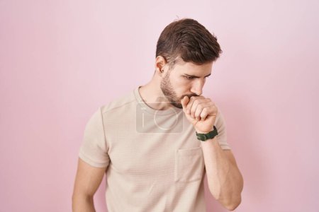 Foto de Hombre hispano con barba de pie sobre fondo rosado sintiéndose mal y tosiendo como síntoma de resfriado o bronquitis. concepto de atención sanitaria. - Imagen libre de derechos