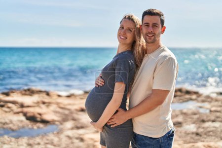 Foto de Hombre y mujer pareja abrazándose el uno al otro esperando bebé en la playa - Imagen libre de derechos