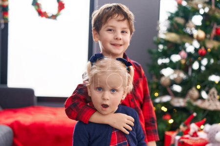 Téléchargez les photos : Adorable garçon et fille qui s'embrassent pour célébrer Noël à la maison - en image libre de droit