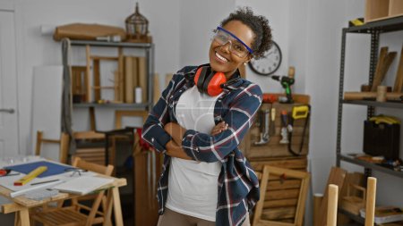 Photo for Confident woman with protective eyewear in a woodworking workshop, showcasing diversity in trades. - Royalty Free Image