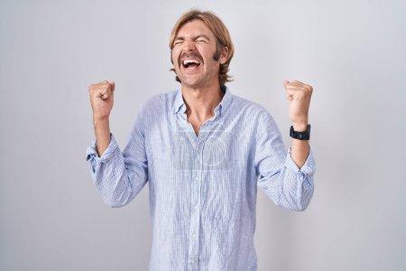 Photo for Caucasian man with mustache standing over white background celebrating surprised and amazed for success with arms raised and eyes closed. winner concept. - Royalty Free Image
