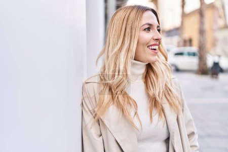 Foto de Young blonde woman smiling confident looking to the side at street - Imagen libre de derechos