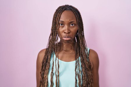 Foto de Mujer afroamericana de pie sobre fondo rosa deprimida y preocupada por la angustia, llorando enojada y asustada. expresión triste. - Imagen libre de derechos