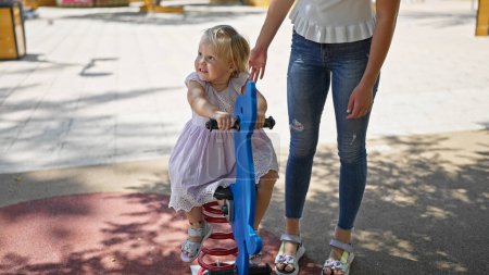 Photo for Caucasian mother-daughter duo confidently smiling, enjoying seesaw fun at the park playground - Royalty Free Image