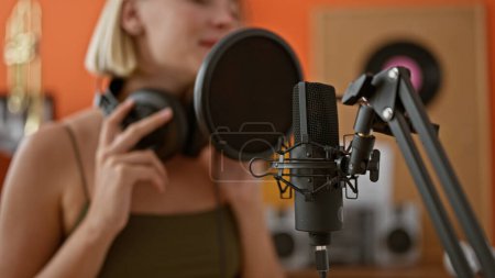 Téléchargez les photos : Jeune femme blonde musicienne chantant chanson dansant au studio de musique - en image libre de droit