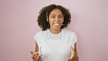 Foto de Mujer afroamericana con auriculares sobre fondo rosa - Imagen libre de derechos